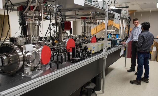 two men standing by research equipment