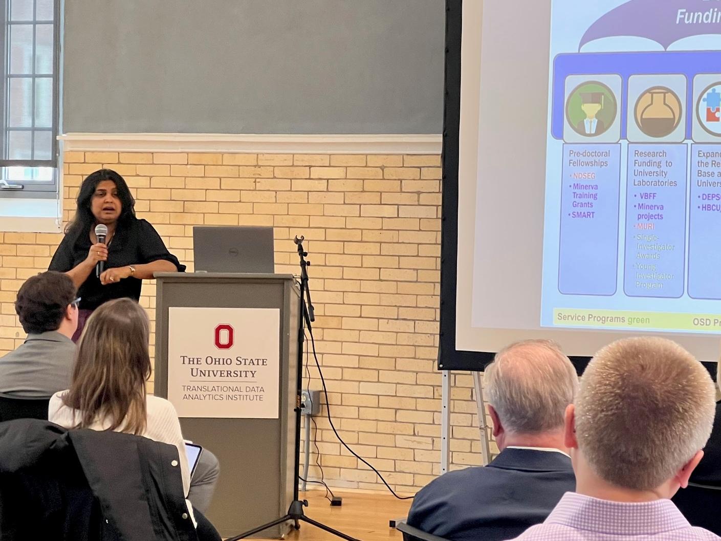 Bindu Nair talks to a group of researchers and staff