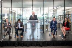 five people stand on the stage at the Pelotonia Research Center opening