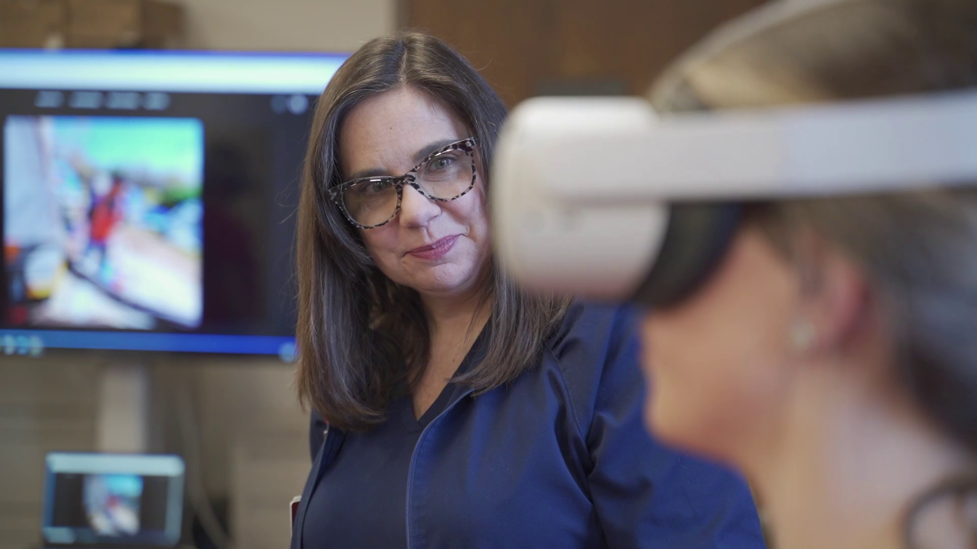 woman watching a person with a virtual reality machine