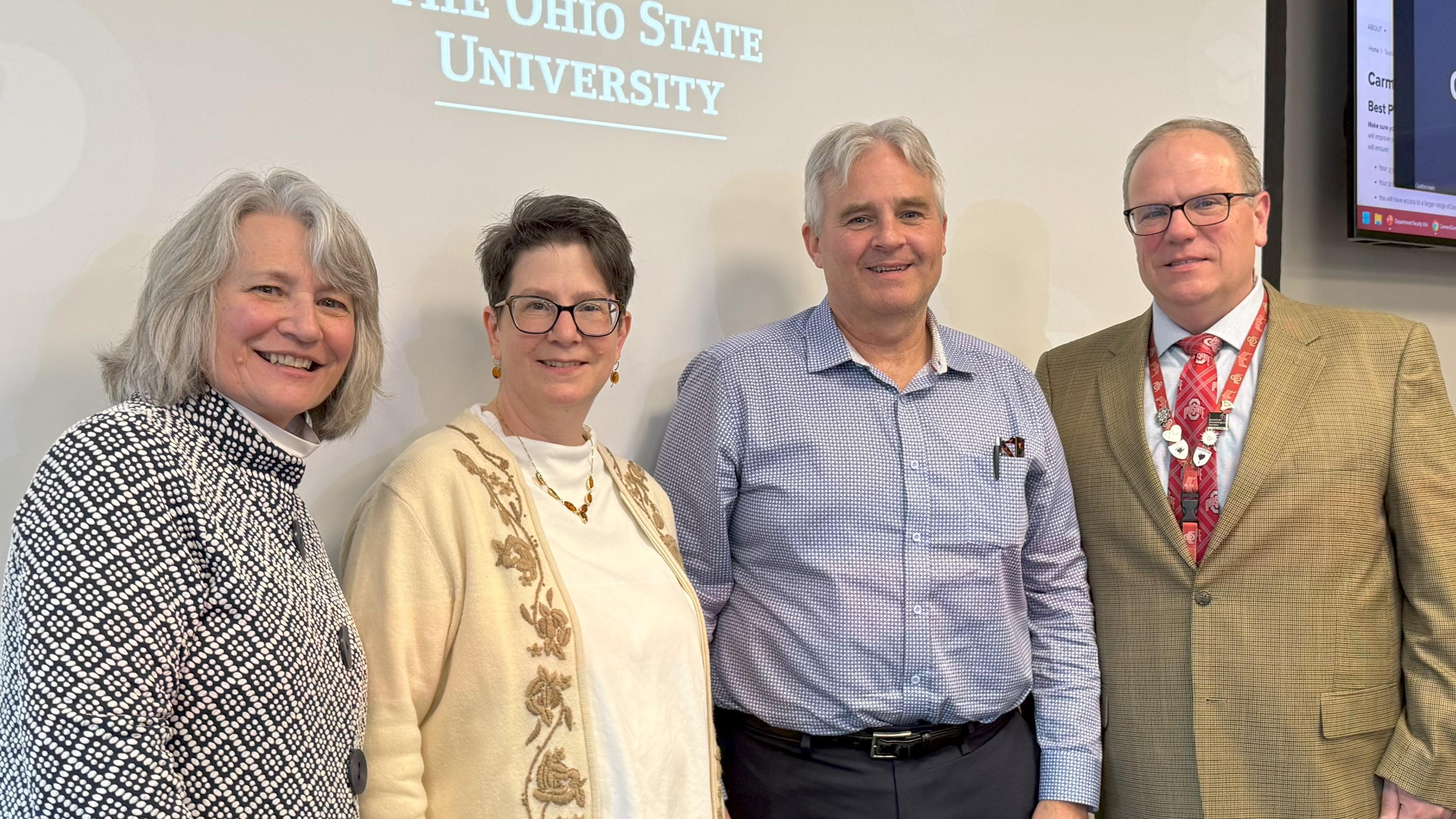 four people standing in front of room