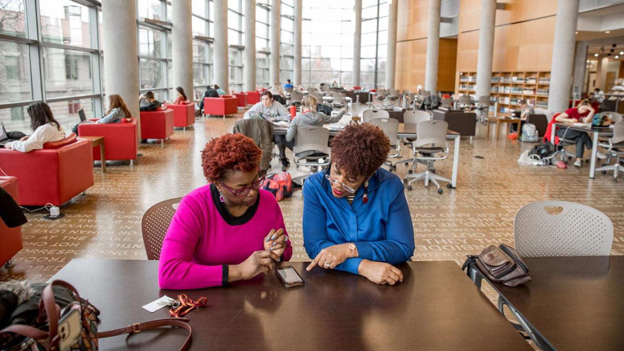 two women talking in the library