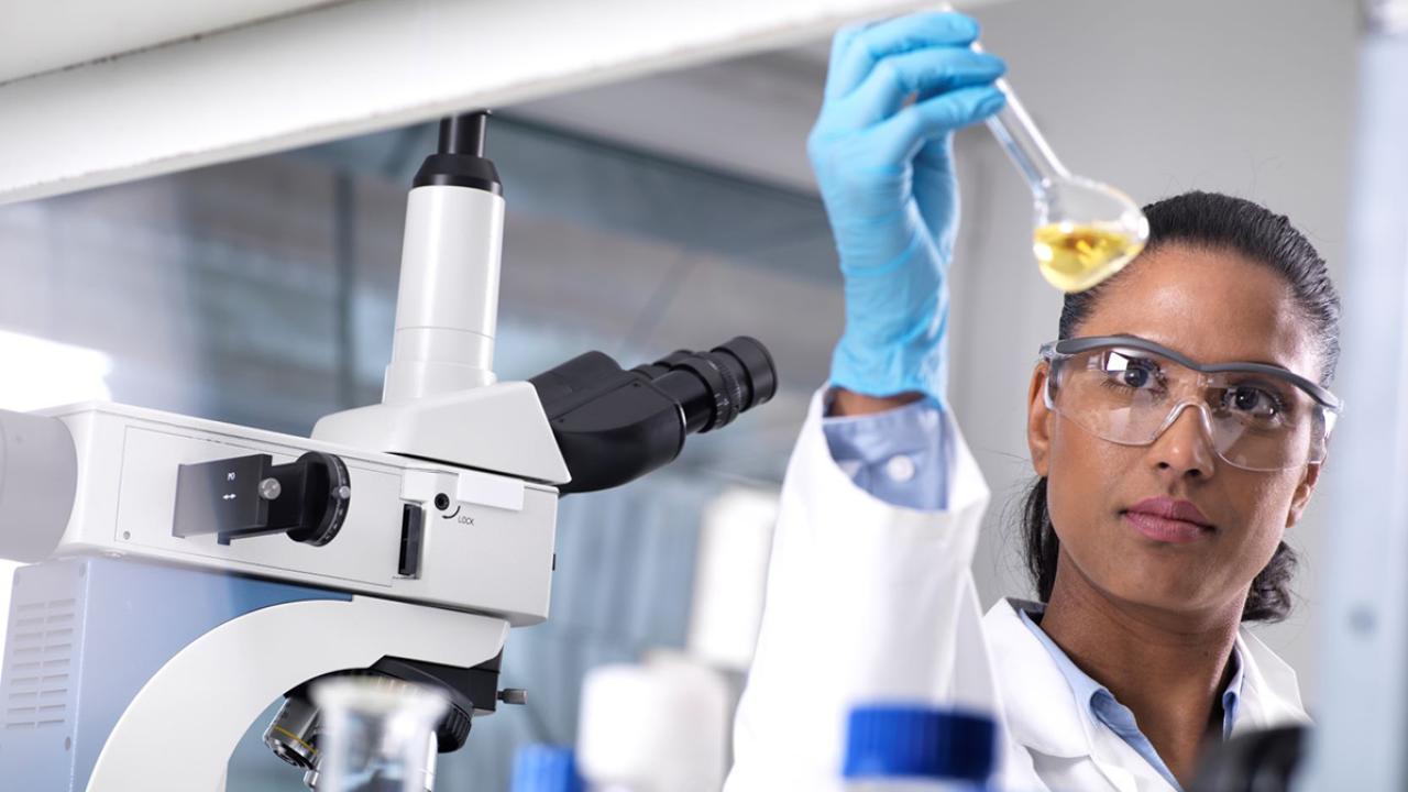 woman holding beaker of liquid in lab