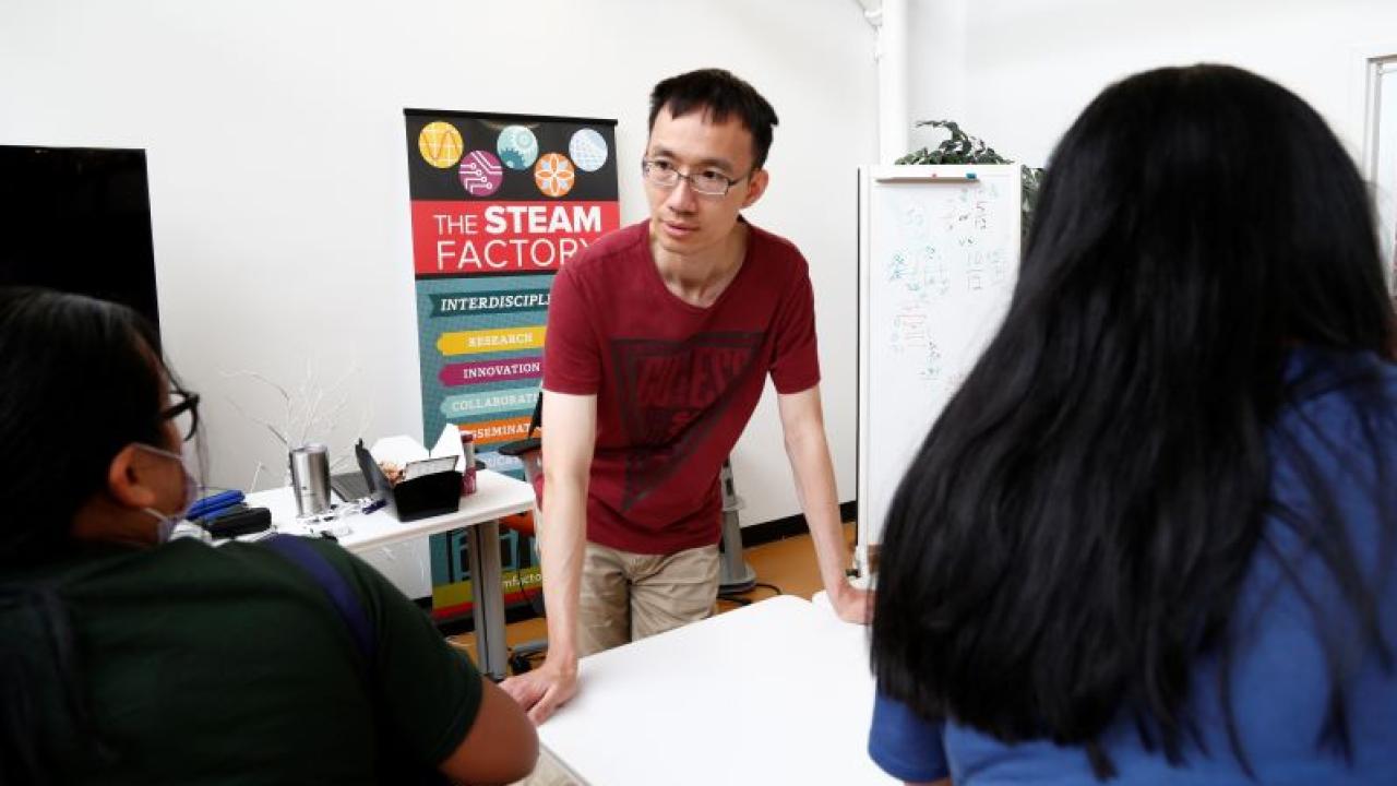 man talking to others at STEAM factory event