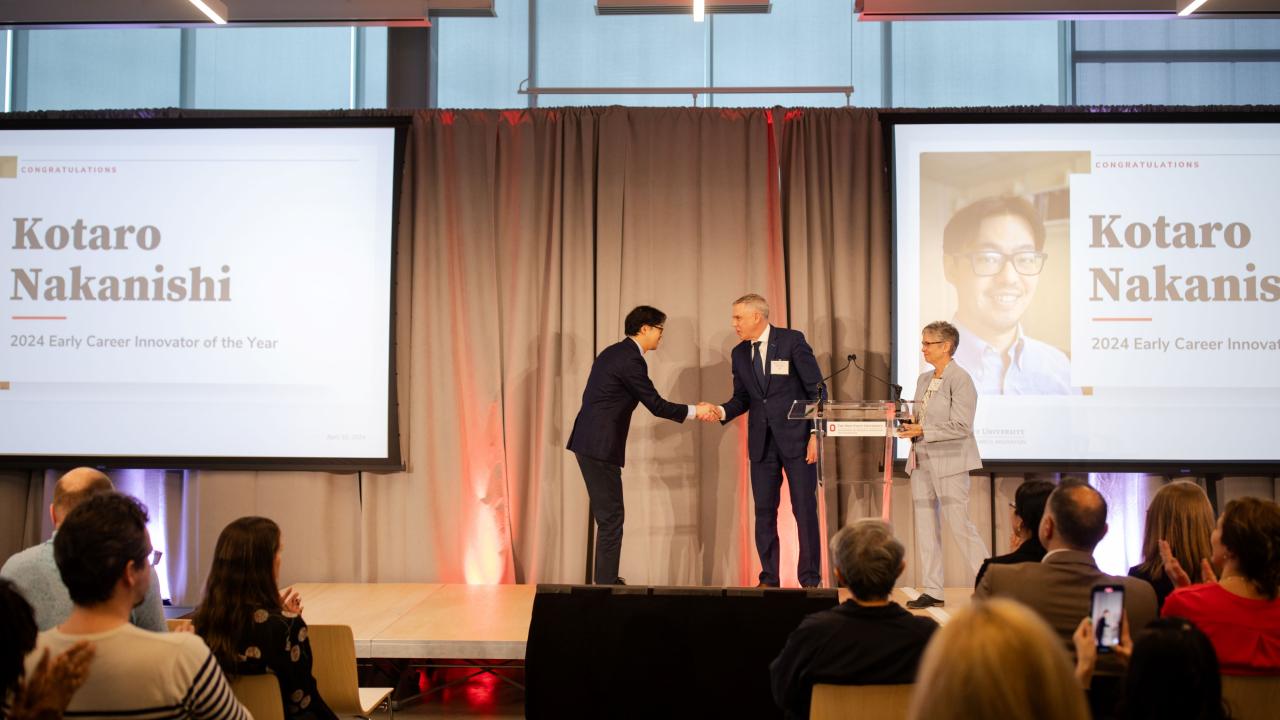 award being presented to man by two people
