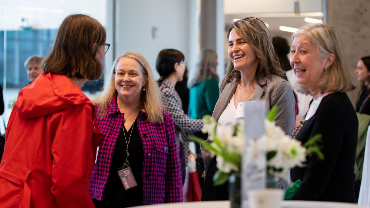 three women listening to another woman speak