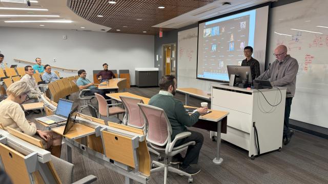 two people standing at a podium in front of a room of people