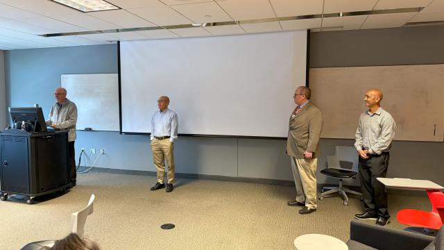 four men standing in front of a room
