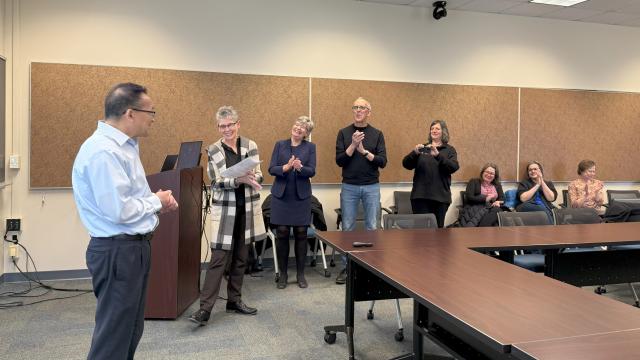five people standing in front of a room